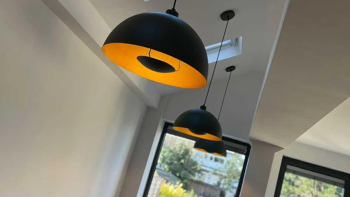 Black dome pendant lights with warm LED illumination over a dining area — professional LED lighting installation by Volt Electrical Solutions