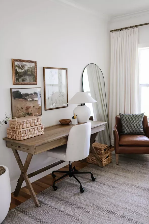 Refined home office staging with desk, artwork, and layered textures