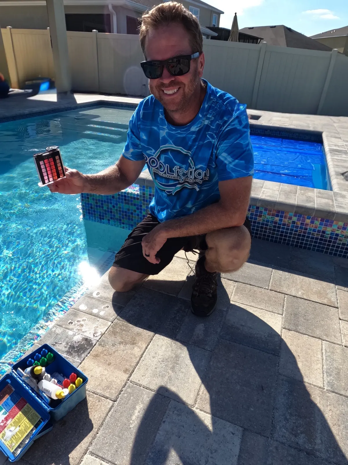 Pool technician testing swimming pool water chemistry with digital equipment to ensure clean, balanced water — professional pool maintenance service by Poolfection.