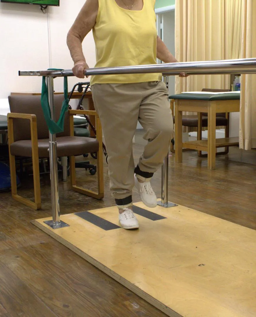 Elderly stroke patient walking o parallel bars