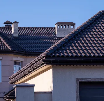a white house with a red roof surrounded by trees
