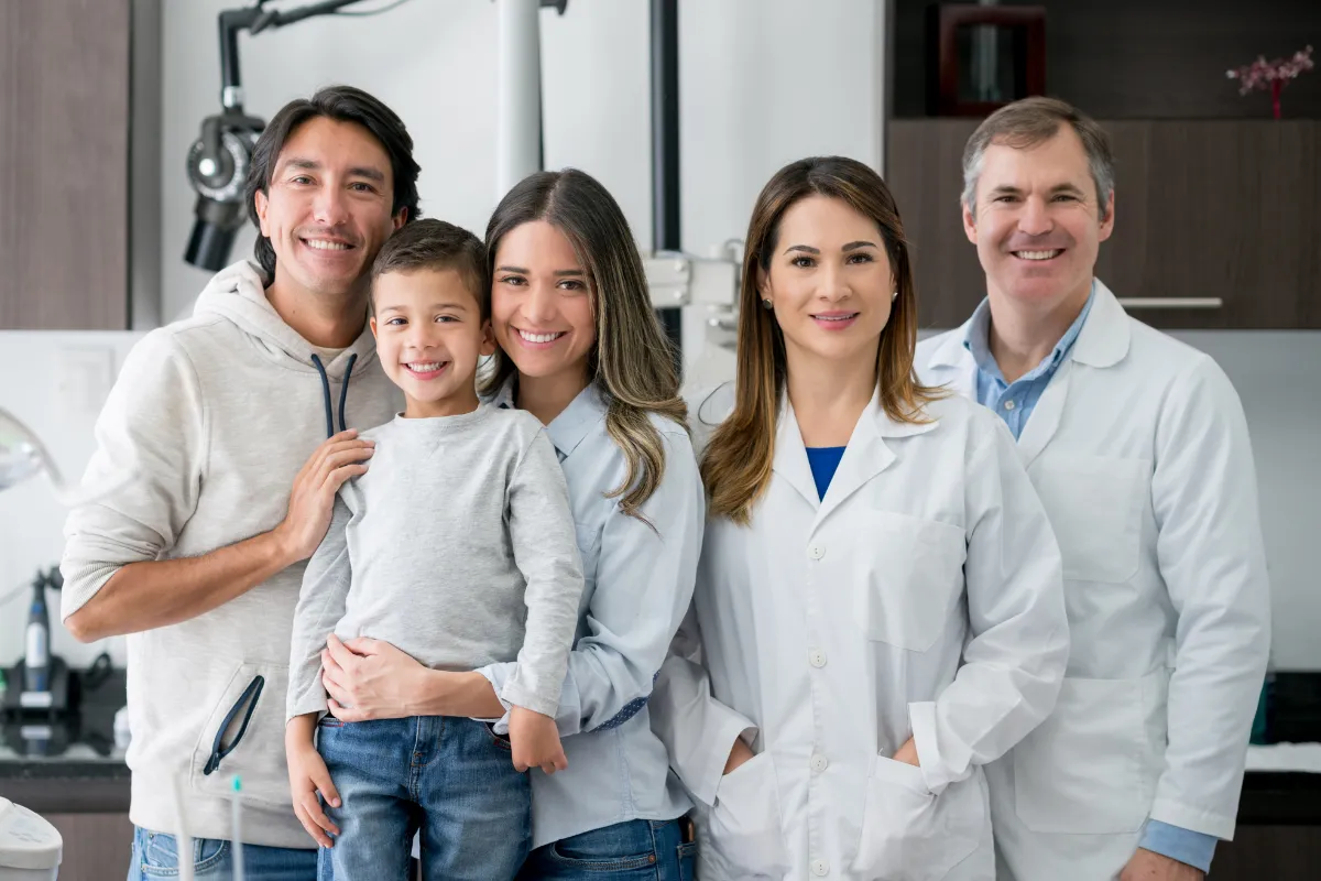 Vancouver family smiling at camera with their dentists happy with dental insurance plan