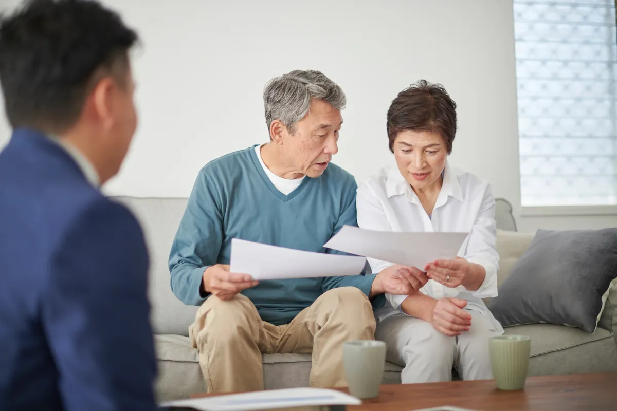 A family in a comfortable living room discussing their whole life insurance options, highlighting financial security and future planning
