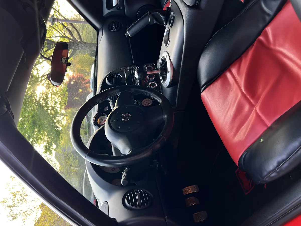 Clean and shiny Porsche leather steering wheel and red interior