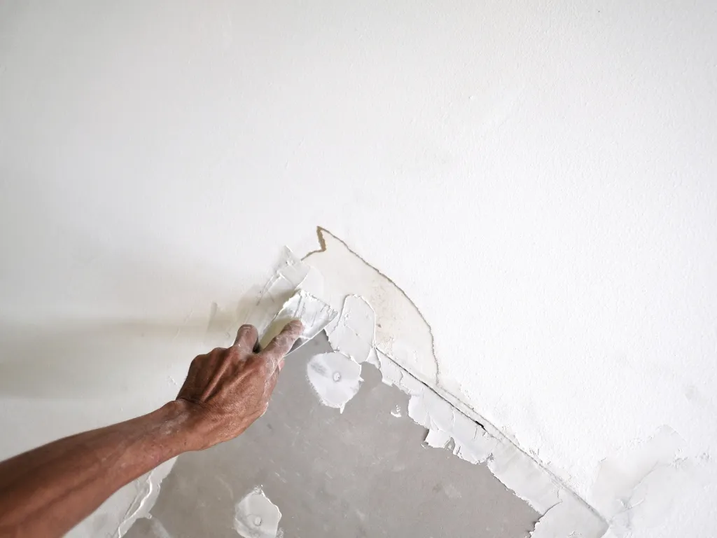 Drywall patch and sanding process before painting in a South Florida home