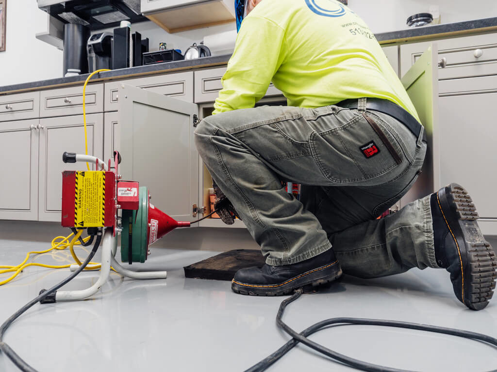 a person holding a wooden spoon in a bucket filled with water