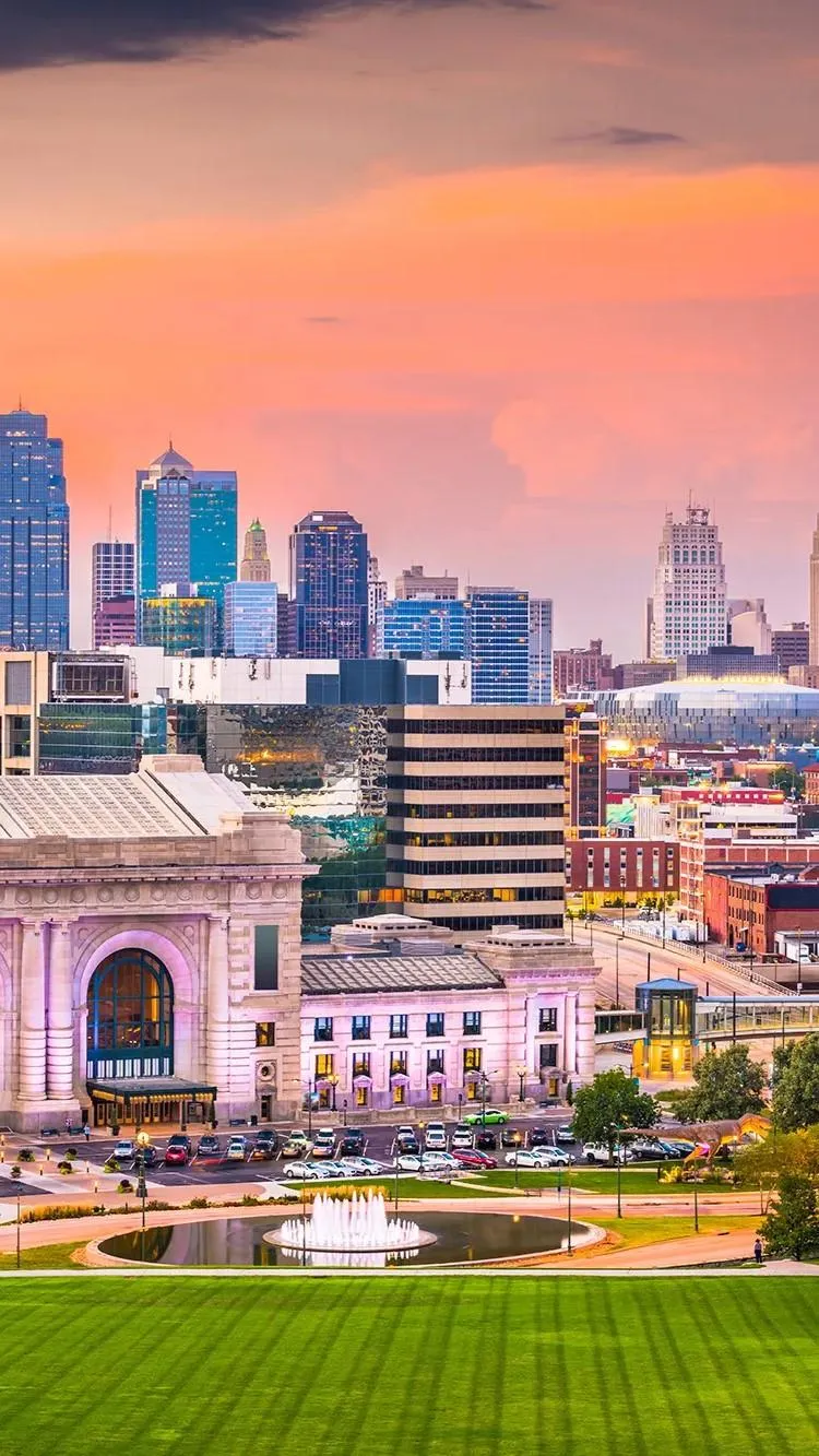 A stunning view of the Kansas City skyline at dusk, with Union Station illuminated, setting the perfect backdrop for a bachelor party weekend.