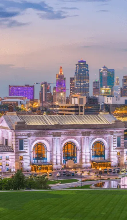 A stunning view of the Kansas City skyline at dusk, with Union Station illuminated, setting the perfect backdrop for a bachelor party weekend.