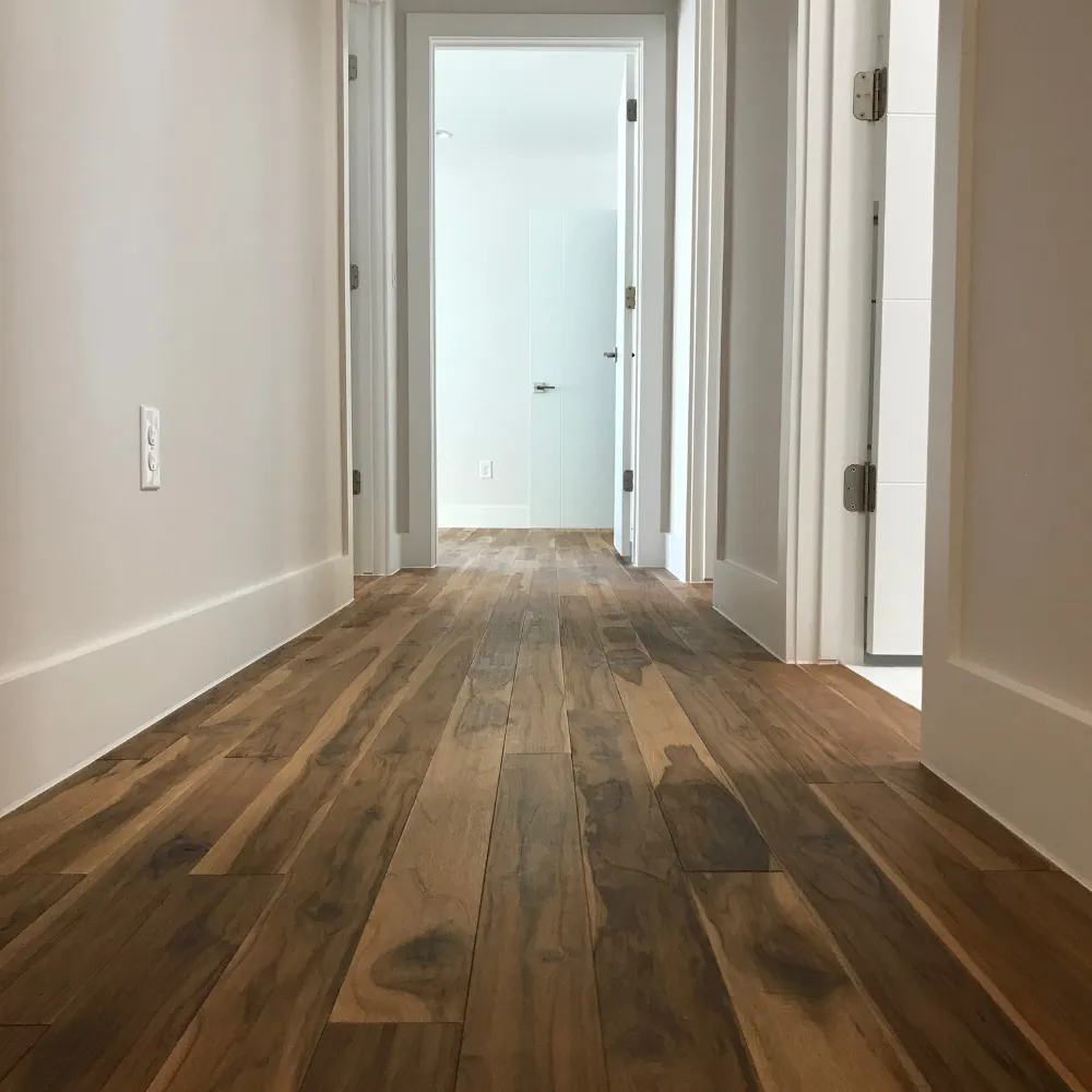  Minimalist hallway with light natural wood flooring, white walls, and open doors leading to bright rooms in a modern home.