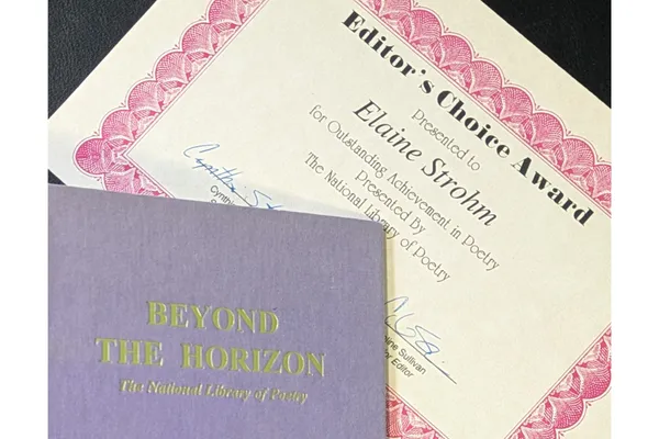 An award certificate beside the cover of a poetry anthology