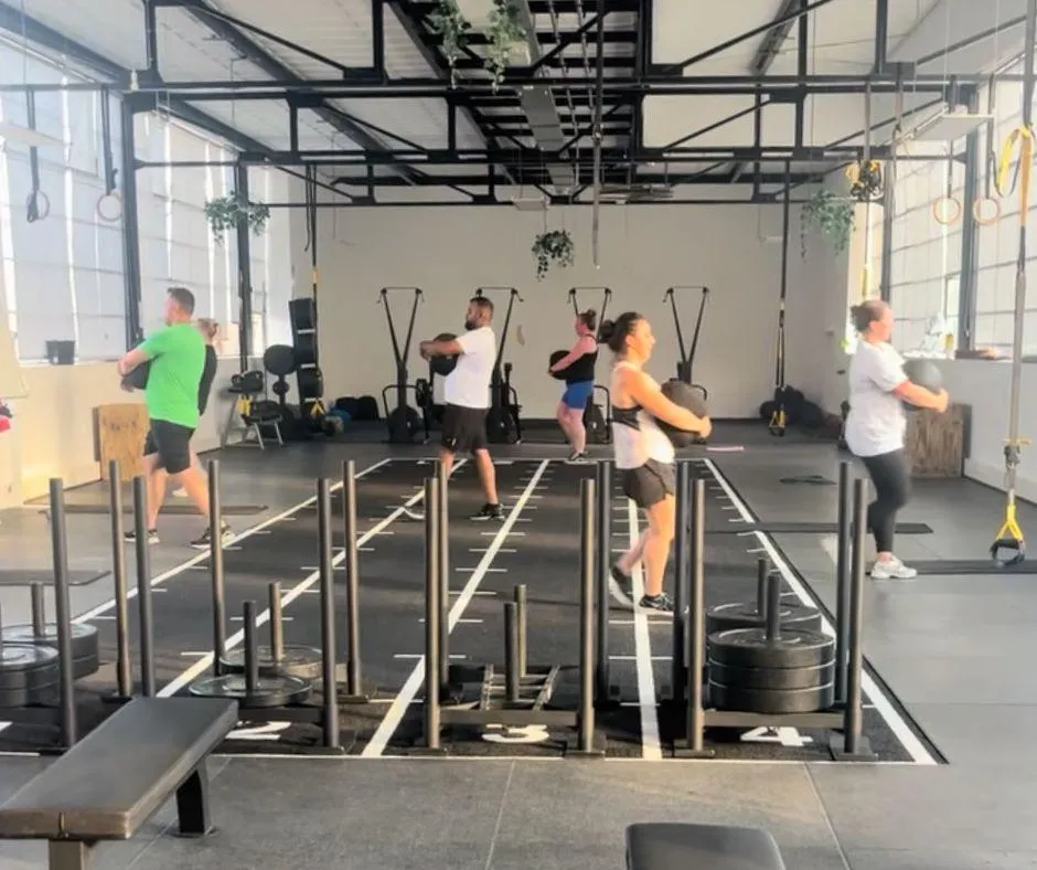 person locking gym plates on barbell