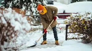 snow and ice removal service creating a clear path in front of a business