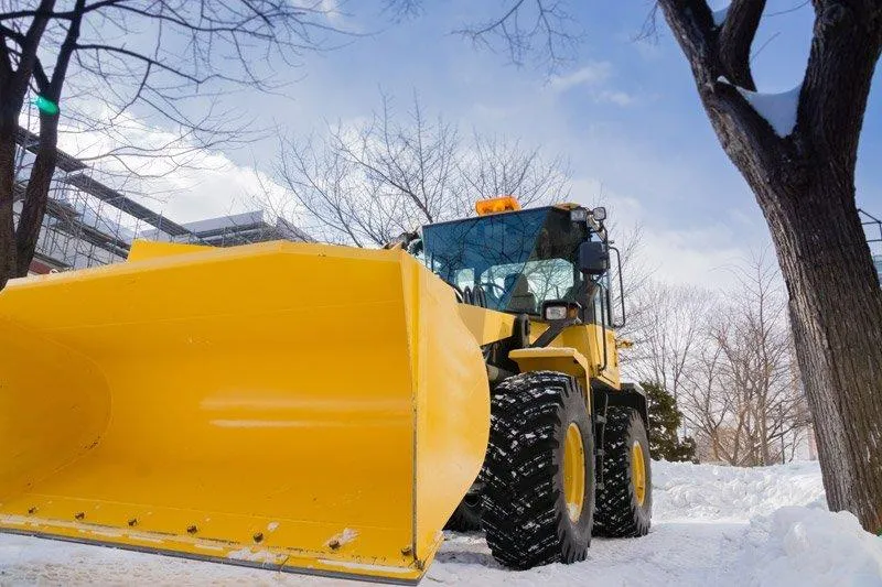 Heavy-duty snow removal equipment clearing snow from a commercial driveway.