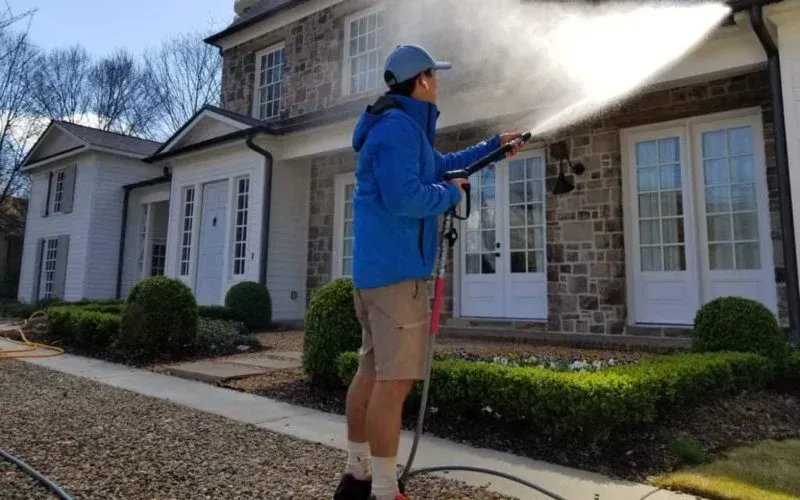Residential power washing removing stains from brick walls