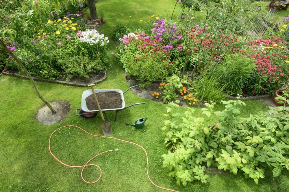 Spring clean-up team removing old foliage and preparing flower beds for new growth"