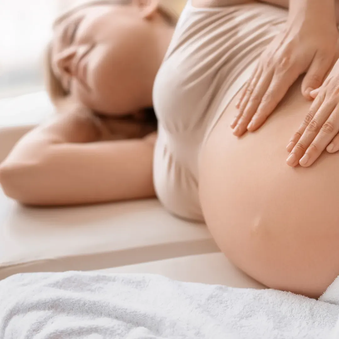 Pregnant woman receiving a gentle prenatal massage focused on easing tension and supporting comfort and circulation.