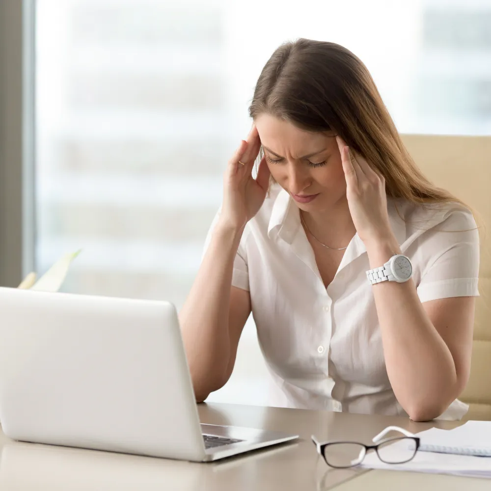 Person holding head experiencing headache pain, illustrating headache and migraine chiropractic care