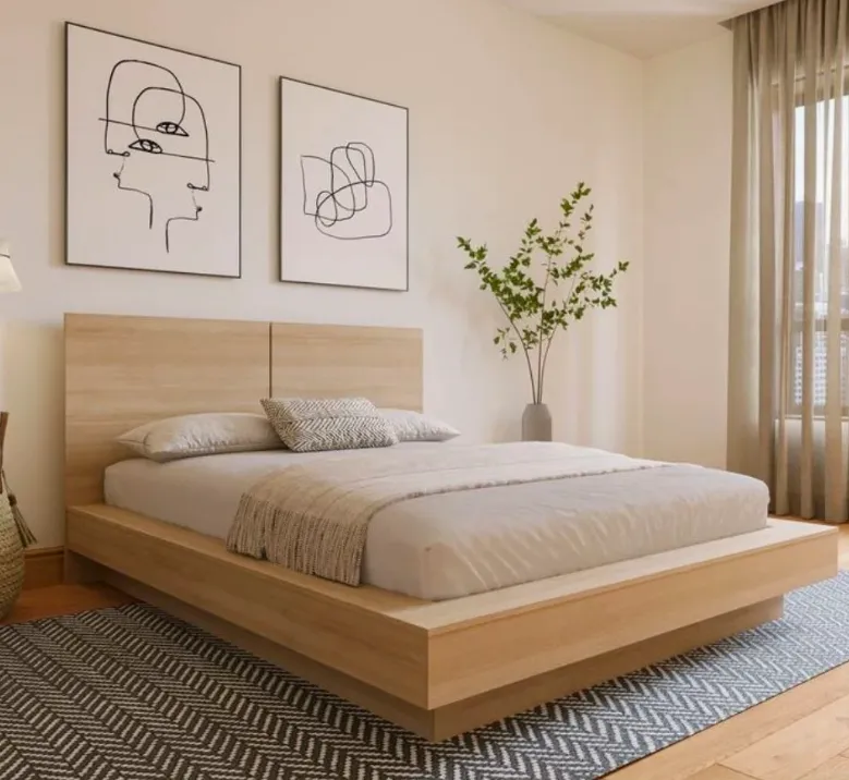 A cheerful cleaner in blue uniform making a bed in a sunlit bedroom, with fresh linens and organized decor, conveying comfort and attention to detail.