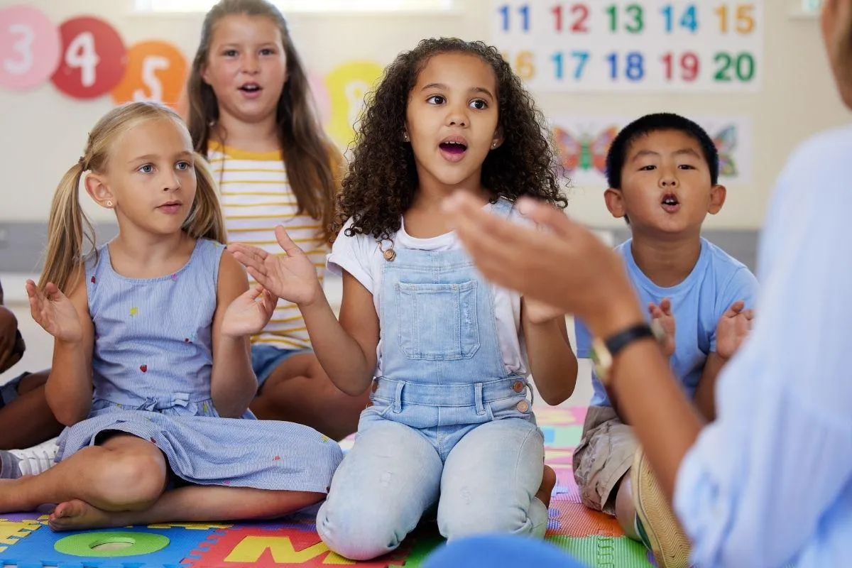 Two children playing an upright piano together, one focusing on the lower keys and the other on the higher ones. Both kids are smiling, engaged in playing, in a cozy room with warm lighting. The scene highlights the joy of collaborative music-making.