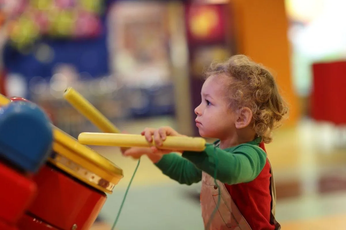 Smiling child playing piano during music lesson