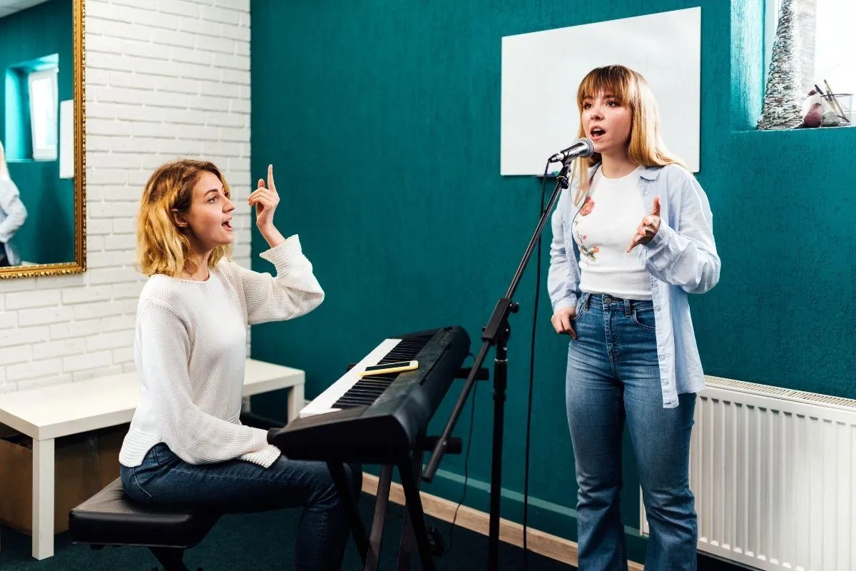 Two children playing an upright piano together, one focusing on the lower keys and the other on the higher ones. Both kids are smiling, engaged in playing, in a cozy room with warm lighting. The scene highlights the joy of collaborative music-making.