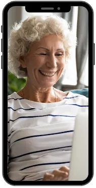 A mobile phone screen shows a smiling mature woman using a laptop.