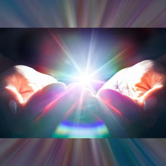 A ball of rainbow light emanates from between two cupped hands.