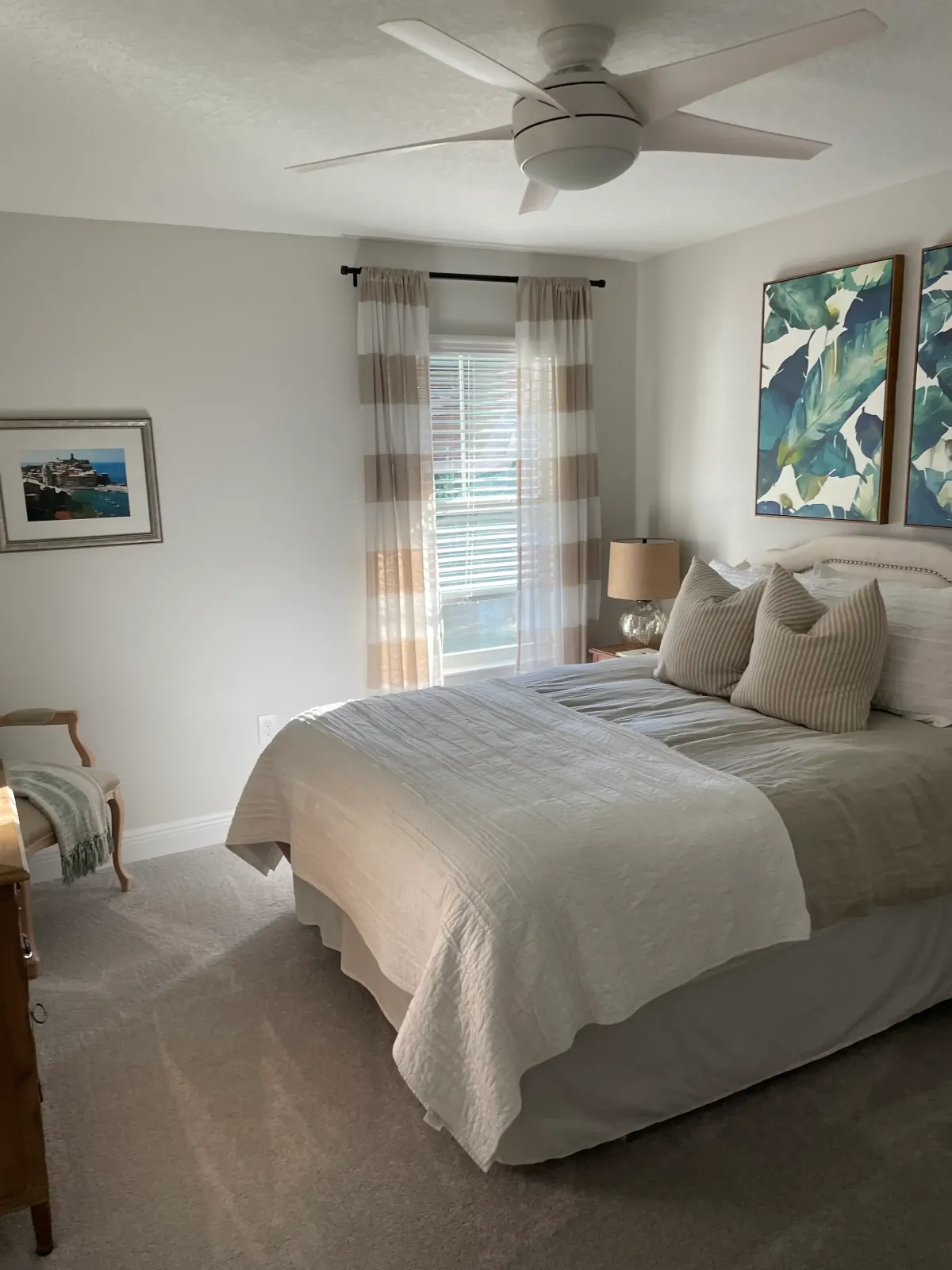 A freshly made bed and clean master bedroom, including dusted surfaces and clean carpets, showing the results of a high-quality residential cleaning service.