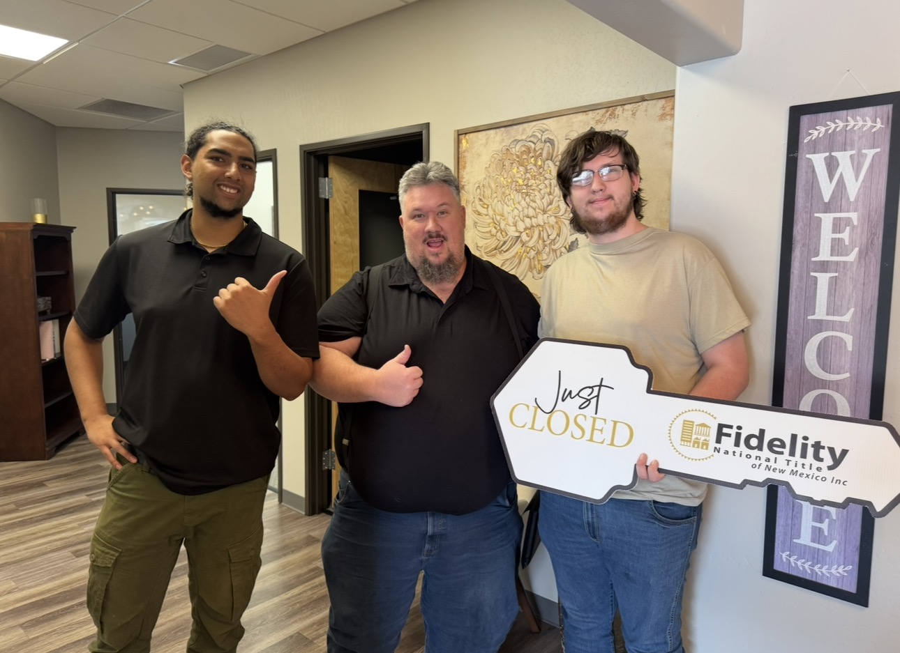 Three people holding a just-closed key at a home closing