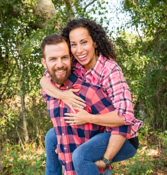 Jules De Jesus Fritz Puerto Rican woman sitting at desk with notebook pen and laptop wearing white shirt and teal necklace