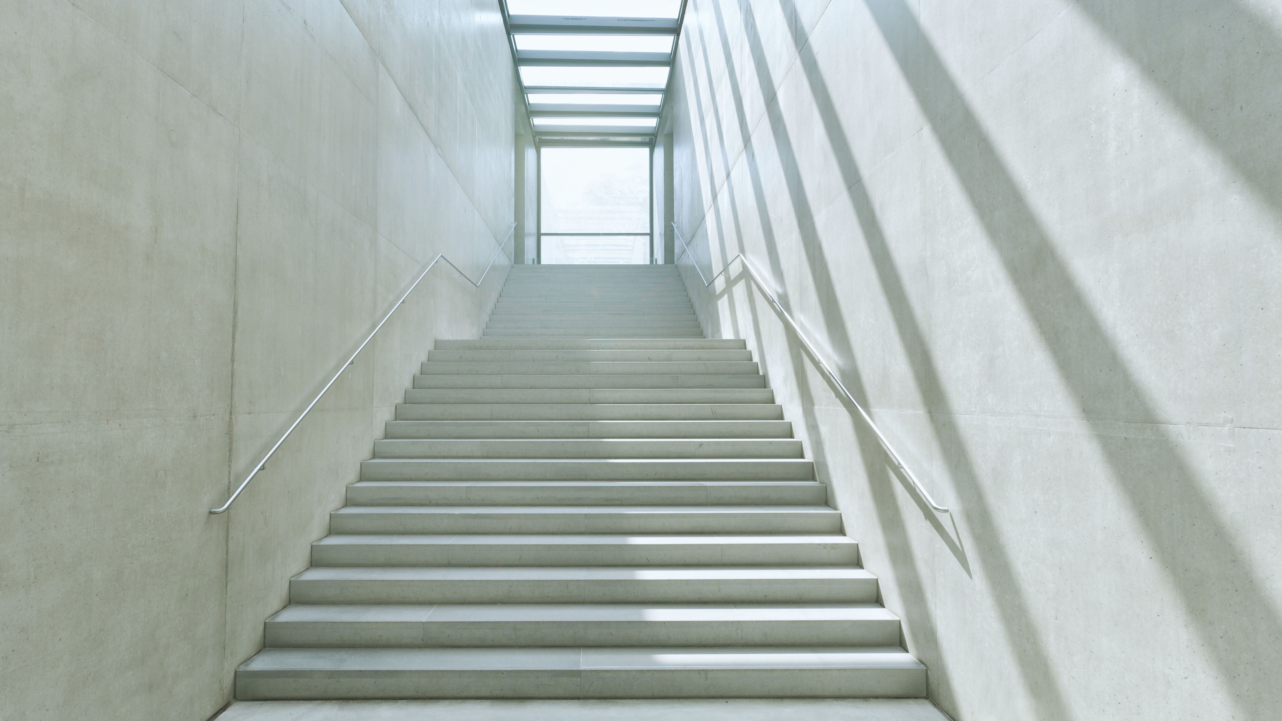 Woman in desk, typing on calculator in natural light.