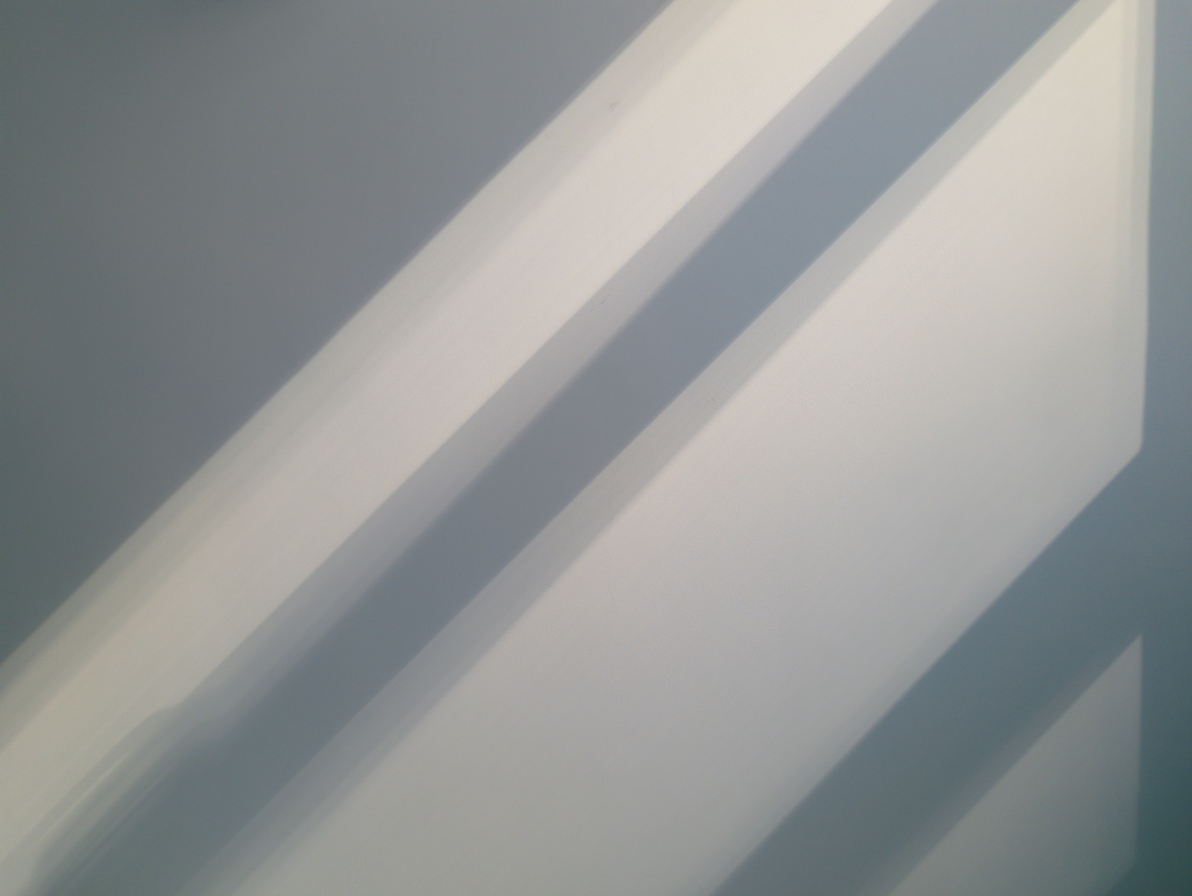 Soft architectural wall with natural light and shadows.