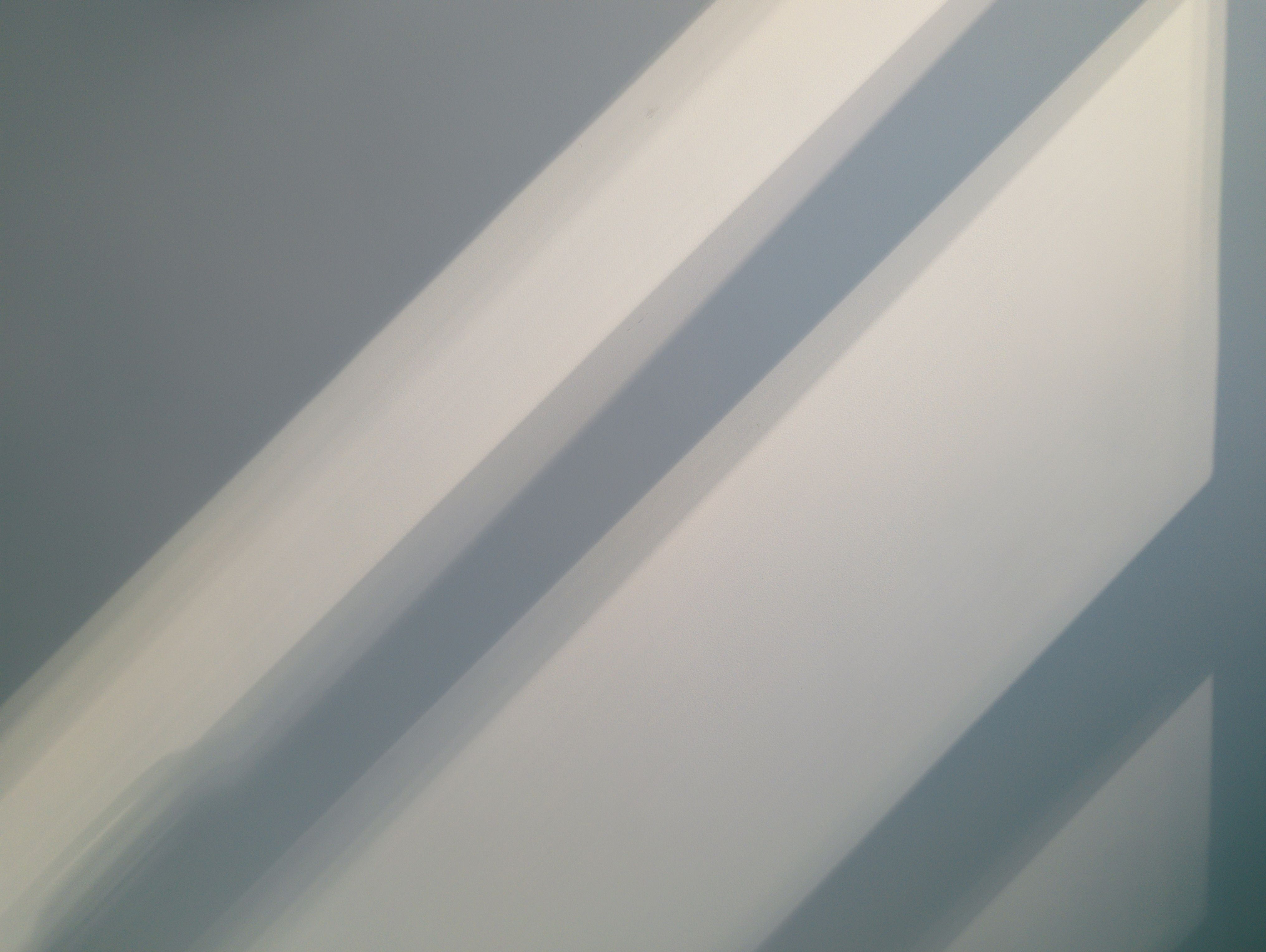 Soft architectural wall with natural light and shadows.