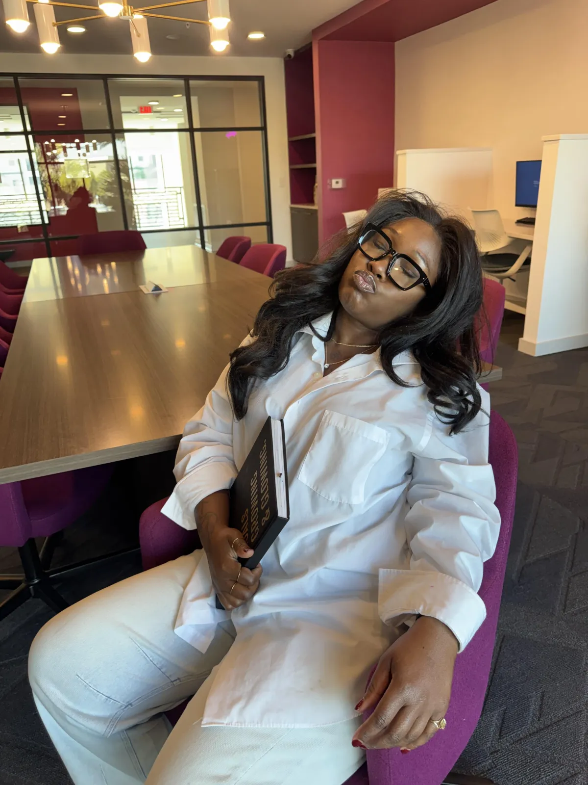 Danee, a 37-year-old woman with warm brown skin and shoulder-length curls, wearing a tailored cream blazer and subtle cross necklace, smiling confidently at camera, hands folded, studio-quality, photorealistic, shadow-free isolated portrait.