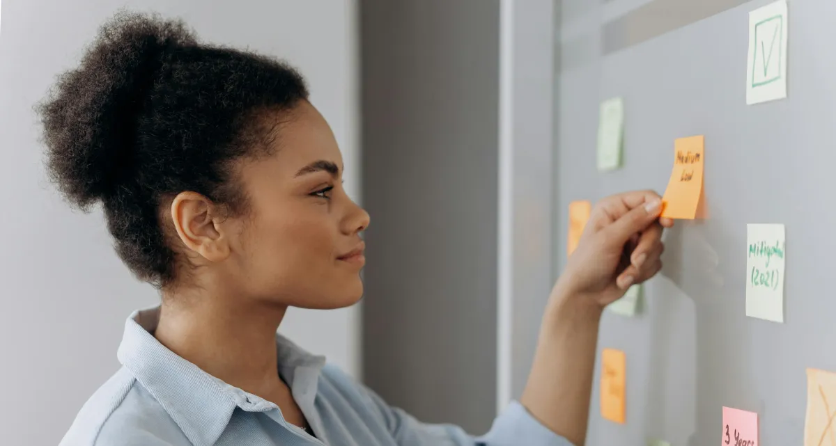 Women putting sticky notes on a board