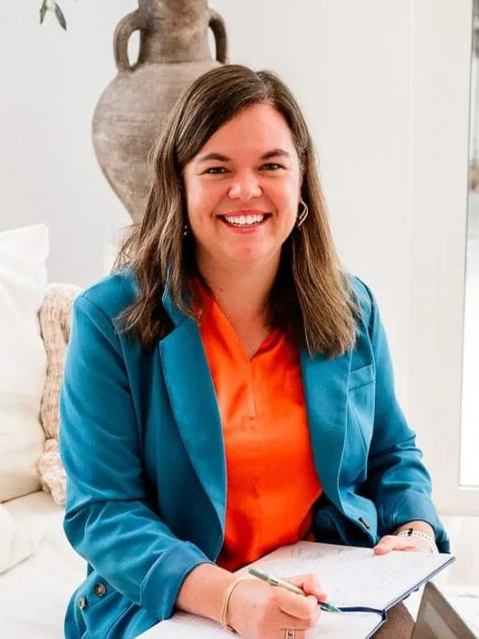 Di Van Der Walt, Speech Pathologist Mentor. She has brown hair and is smiling whilst holding a notebook and pen.