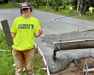 Concrete finisher standing beside freshly poured concrete on a Fox Valley jobsite