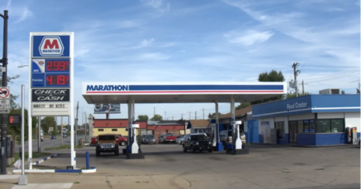 Marathon gas station with fuel pumps, price sign, and convenience store under a clear blue sky