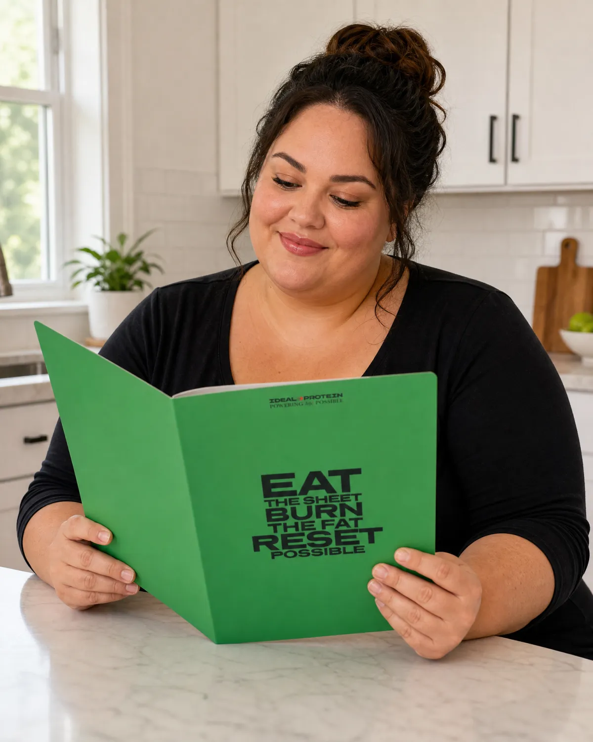 Woman reading the Ideal Protein protocol guide in a bright kitchen, representing a medically guided three-phase fat loss program