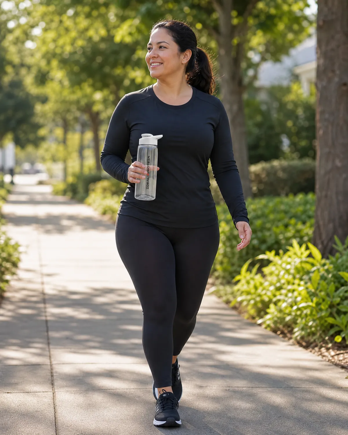 Woman walking confidently along an outdoor path, representing those restarting the Ideal Protein Protocol at a gradual, low-barrier pace with structured coach support