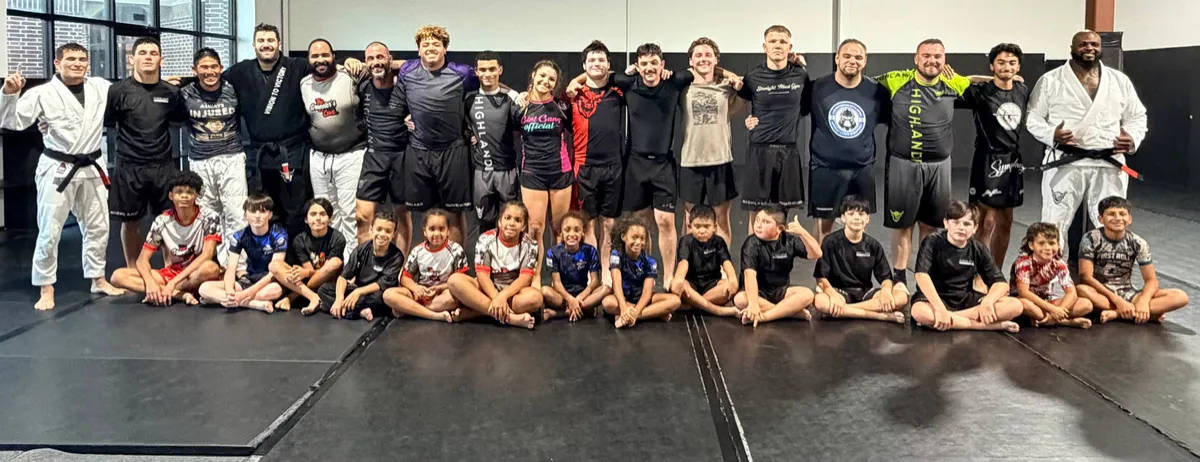 Highland Jiu Jitsu students and coaches smiling together after a fun mixed-age class