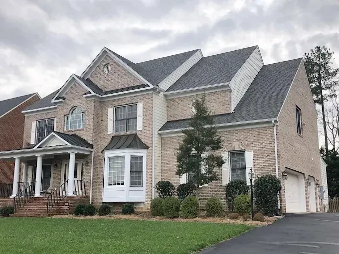 Freshly painted warm neutral living room in Richmond VA with elegant windows, modern furniture, sleek hardwood floors, and decorative touches