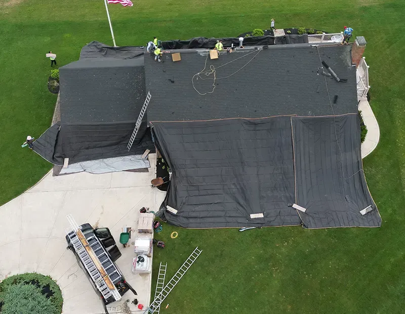 Lema Construction Inc team performing roofing replacement in Abington on a residential home