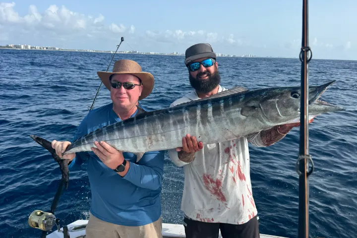 Happy anglers holding a big fish on a RingMaster Charters half-day trip off Pompano Beach, Florida.