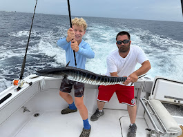 Cockpit POV from RingMaster with trolling spread and bright teal wake during a half-day charter