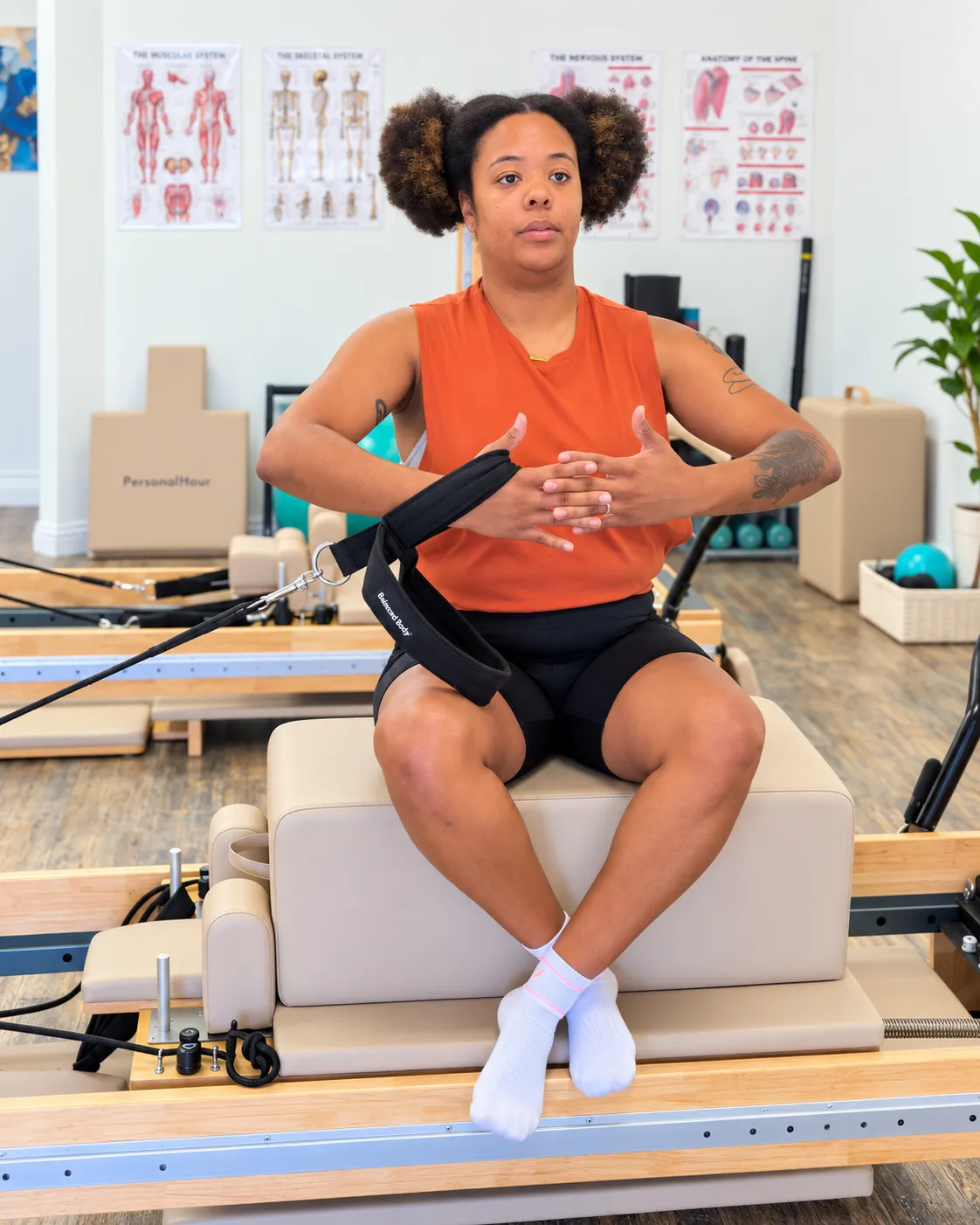 Davonna instructing a client on a reformer machine in a boutique Pilates studio