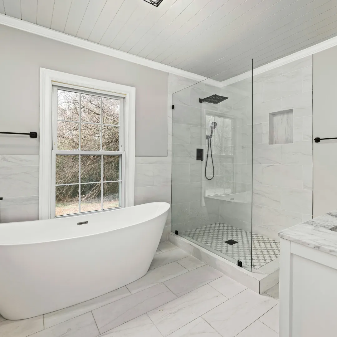 Modern white kitchen remodel with center island, quartz countertops, pendant lighting, and stainless steel appliances.