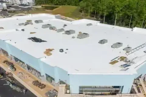 Aerial view of newly constructed commercial building with white flat roof in Blaine