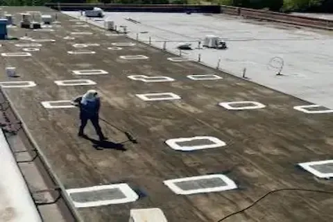 Roofer sealing roof penetrations during flat roof repair by Blaine Commercial Roofing