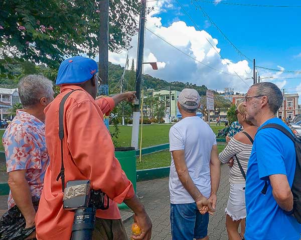 Kirk Elliott guiding visitors through downtown Castries Saint Lucia during a cultural walking experience near Derek Walcott Square.